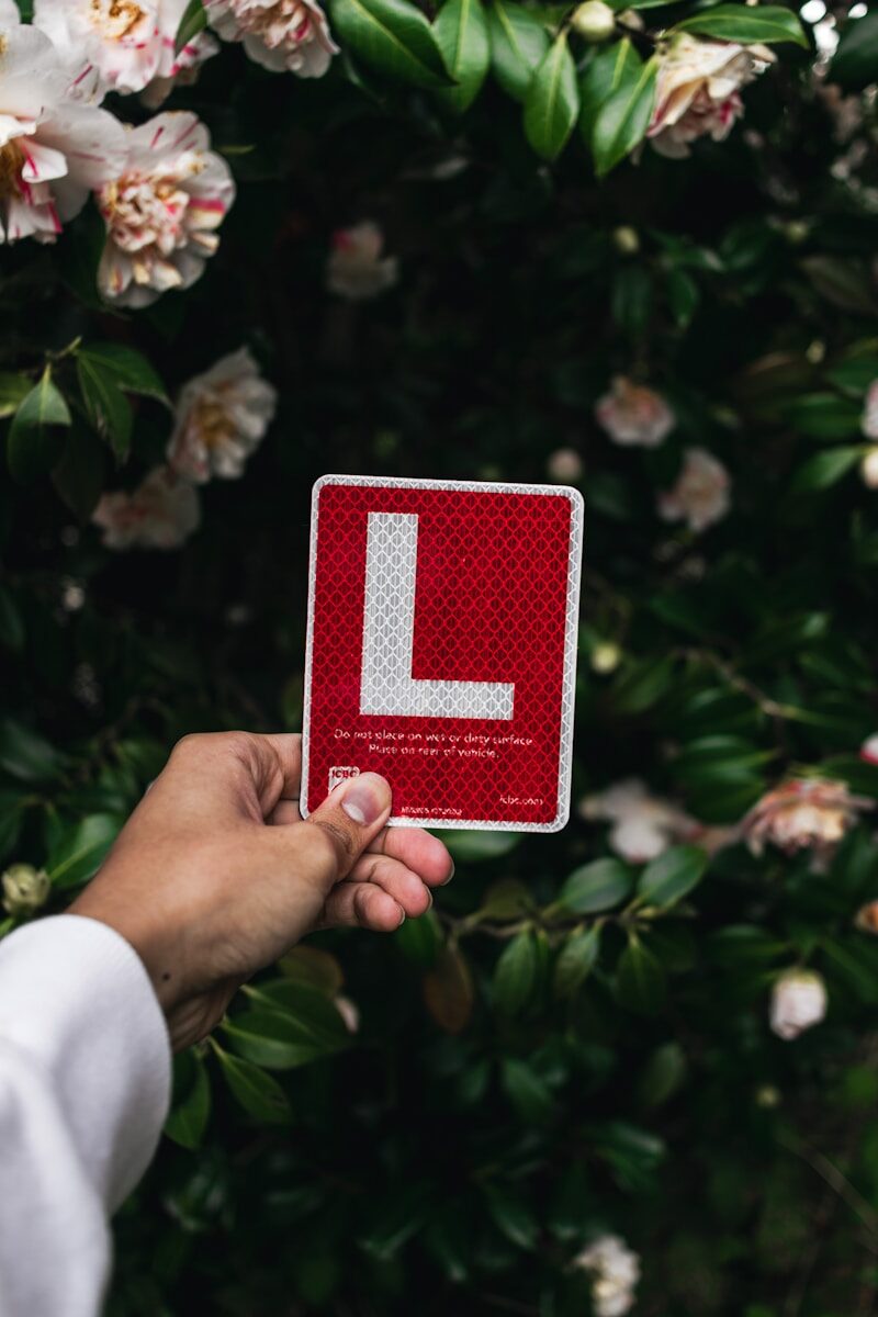 a hand holding a red and white card